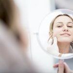 Aesthetic surgery, woman looking in mirror